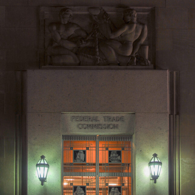 The Federal Trade Commission office glows softly inside, contrasting with the darkness outside — coverage from STAT