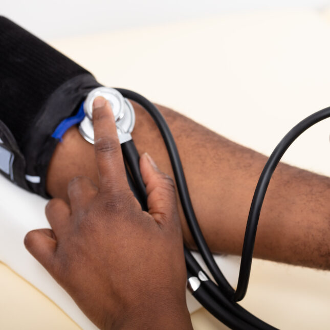 A doctor measures a patient's blood pressure using a manual monitor — first opinion coverage from STAT