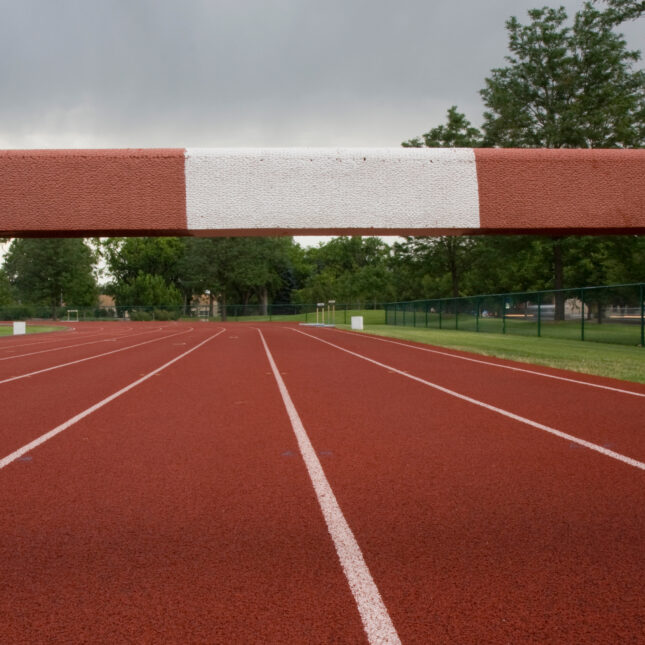 A steeplechase barrier blocks running tracks under a gloomy sky — first opinion coverage from STAT