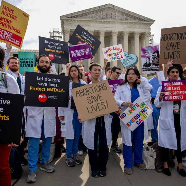 In front of the Supreme Court, a group of doctors in white coats raise signs advocating for the Emergency Medical Treatment and Active Labor Act and abortions — politics coverage from STAT