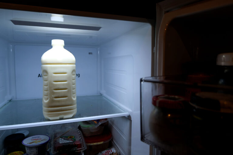 A bottle of raw milk inside a refrigerator.